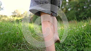 girl running on the grass in the park in summer. happy family childhood dream concept. a little girl with bare feet runs