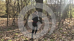 A girl running and hiding in a forest behind trees