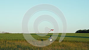 Girl running with a kite in the field