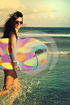 Girl running laughing cheerful having fun with boogieboard photo