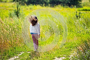 Girl running on the road in the field