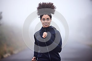 Girl, running and smile in morning fog in nature for health, fitness or wellness on road in portrait. Woman, person and
