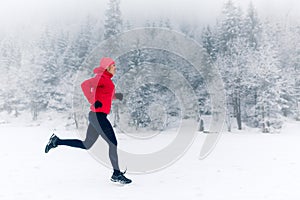 Girl running on snow in winter mountains