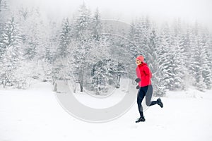 Girl running on snow in winter mountains. Sport, fitness inspiration and motivation. Young happy woman trail running in mountains