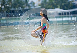 Girl running through the wading pool at water park