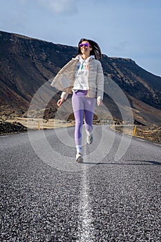 the girl is running through the wide open road with her bike