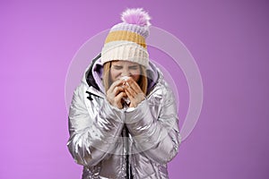 Girl runny nose sneeze tissue press napkin face got ill feeling unwell sick heading hospital standing purple background
