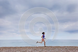 The girl runs along the sandy beach