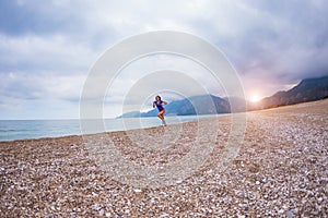 The girl runs along the sandy beach