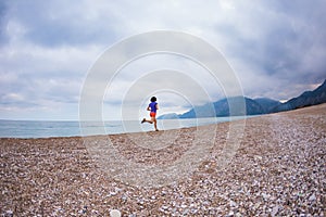 The girl runs along the sandy beach