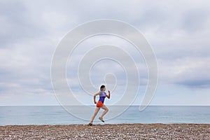 The girl runs along the sandy beach