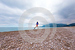 The girl runs along the sandy beach