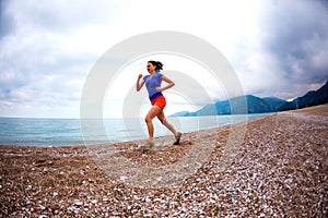 The girl runs along the sandy beach