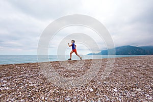 The girl runs along the sandy beach