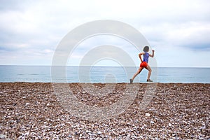 The girl runs along the sandy beach