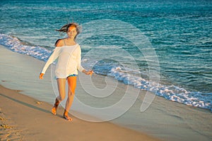 Girl runs along the surf line