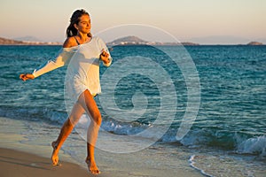 Girl runs along the surf line