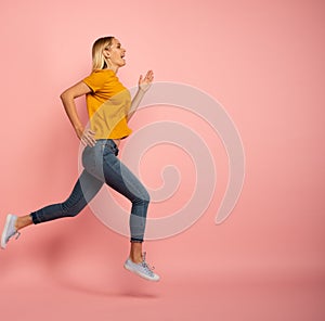 Girl runs fast. Concept of energy and vitality. Pink background