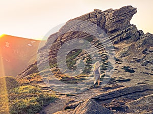 Girl runs in rocky mountains at sunset. Mount Vuhaty Kamin. Chornohora, Ukraine.