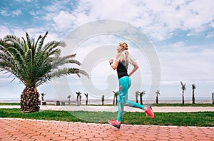 Girl runs on the sea embankment. Active life style