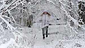 The girl runs through the snowy magic forest.
