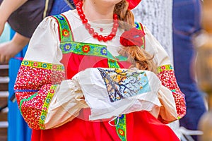 The girl in the Russian national costume is engaged in embroidery
