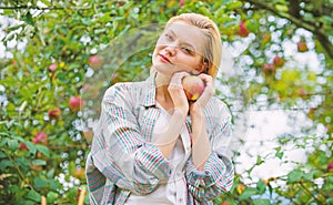 Girl rustic style gather harvest garden autumn day. Farmer pretty blonde with appetite red apple. Harvesting season