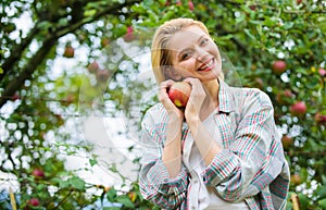 Girl rustic style gather harvest garden autumn day. Farmer pretty blonde with appetite red apple. Local crops concept