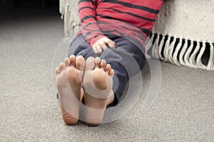 Girl`s bare feet. Foot heel. Girl sitting on the floor. European photo
