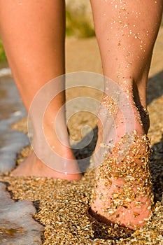 Girl's barefoot feet in sea surf