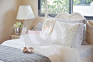 Girl`s bedroom with ballet shoes and dolls on bed at home