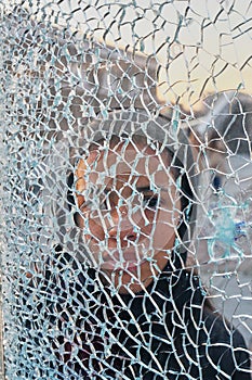 The girl`s face behind the broken glass