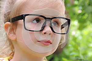 Girl`s face with glasses a black frame