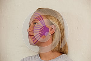 Girl& x27;s face in profile with kinesiological tapes for cheeks