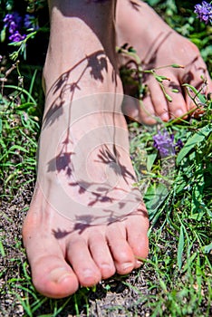 On the girl`s feet, the shadow of flowers