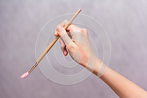 Girl's hand holding a brush for painting