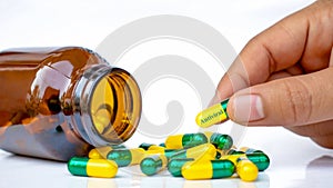 The girl`s hand picks up an antiviral capsule.