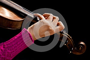 Girl's hand on the strings of a violin