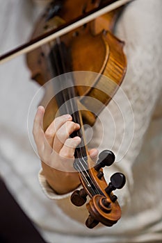 Girl's hand on the strings of a violin