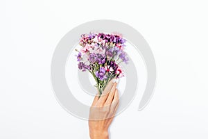 Girl`s hand with white manicure holding small bouquet