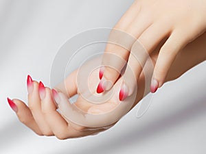 Girl& x27;s hands with a beautiful pale pink ombre manicure . Beautiful woman& x27;s hands on light background