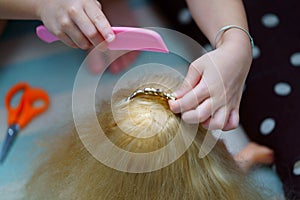 Girl`s hands comb doll`s hair