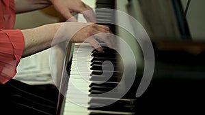 Girl`s hands on the keyboard of the piano. The girl plays piano,close up piano. Hands on the white keys of the Piano