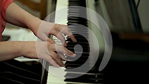 Girl`s hands on the keyboard of the piano. The girl plays piano,close up piano. Hands on the white keys of the Piano