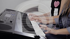 Girl`s hands on the keyboard of the piano. The girl plays piano,close up piano. Hands on the white keys of the Piano