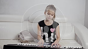 Girl`s hands on the keyboard of the piano. The girl plays piano,close up piano. Hands on the white keys of the Piano