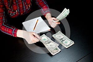 Girl`s hands lay out modest savings in different piles. distributes spending