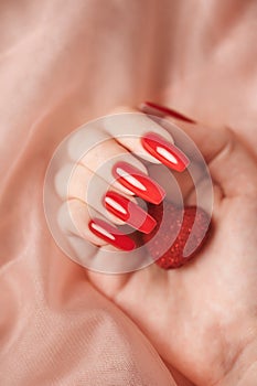 Girl`s hands with red manicure and decoratine heart