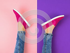 The girl`s legs in jeans and red sneakers on a colorful floor. The view from the top.