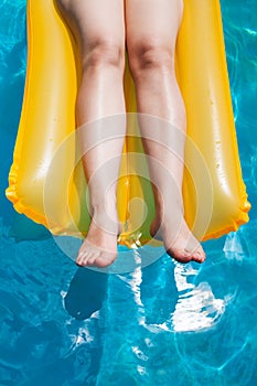 Girl's legs on yellow inflatable mattress